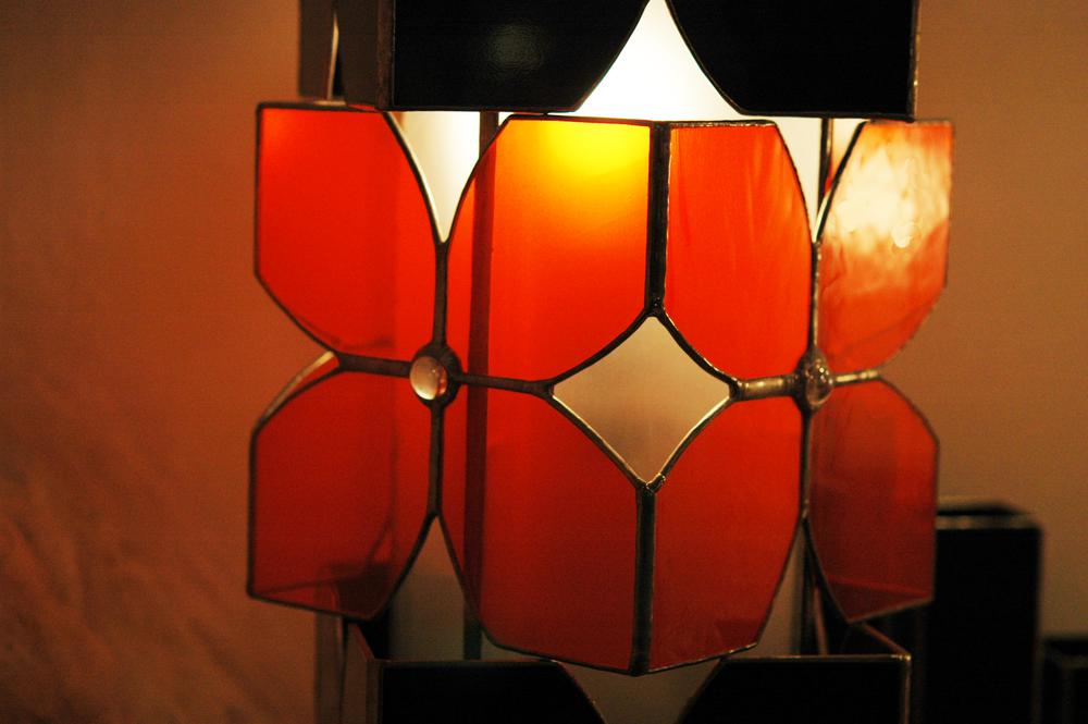 Vitraux oranges et noirs pour cette lampe à poser. Equipée de deux ampoules elle constitue une source de lumière intéressante en lampe d'appoint intégrée à la déco, sur un bureau ou une table de chevet.